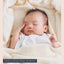 生成りのベビーケットの上で眠る赤ちゃん。